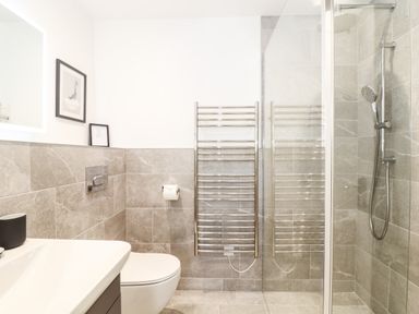 A bathroom with a sink toilet towel rack and a shower at Trevilges Cottage Trewennack near Helston