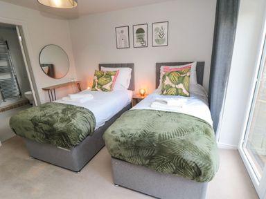 A bedroom with two single beds and green bedding at The Annexe in Bridlington