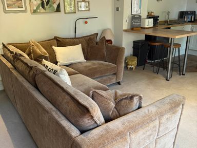 A living room with a sofa and kitchen area at The Annexe in Bridlington