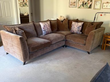 A living room with a brown sofa and decorative pillows at The Annexe in Bridlington