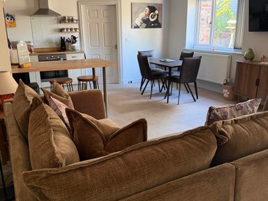 A living room with a sofa and dining area at The Annexe in Bridlington