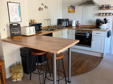 A kitchen with a counter and stools at The Annexe Bridlington