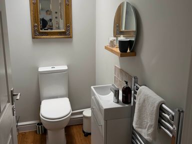 A bathroom with a sink, toilet, and mirror at The Annexe in Bridlington