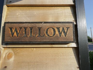 A wooden sign with the word Willow carved on a wooden surface at Willow in Kemble