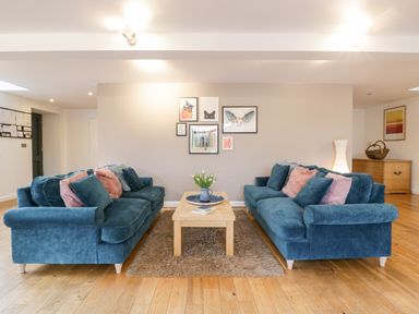 A living room with two blue sofas facing each other and a wooden coffee table in the middle at Owl Barn Marston Stannett near Leominster