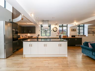 A kitchen with an island, stainless steel appliances and a blue couch at Owl Barn in Marston Stannett near Leominster