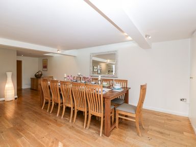 A dining room with a long wooden table and wooden chairs at Owl Barn in Marston Stannett near Leominster