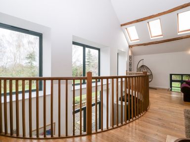 Upper floor landing with wooden railing skylights and hanging chair at Owl Barn in Marston Stannett near Leominster