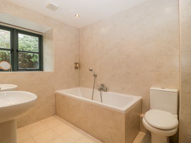 A bathroom with a bathtub sinks toilet and window at Owl Barn in Marston Stannett near Leominster