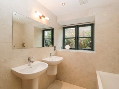 A bathroom with two sinks a large mirror a window and a bathtub at Owl Barn Marston Stannett near Leominster