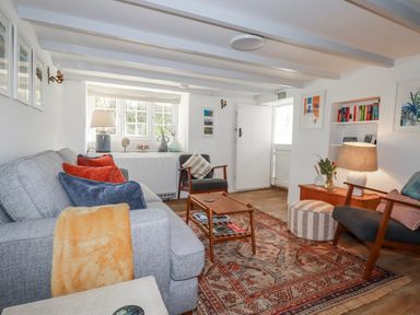 A living room with a couch and a table at Ivy Cottage in Trenale near Tintagel