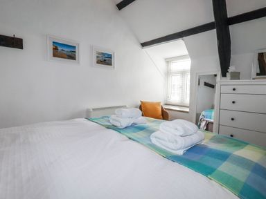A bedroom with a bed and towels on top at Ivy Cottage in Trenale near Tintagel
