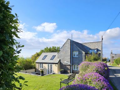 A house with a garden and bench at Ivy Cottage in Trenale near Tintagel