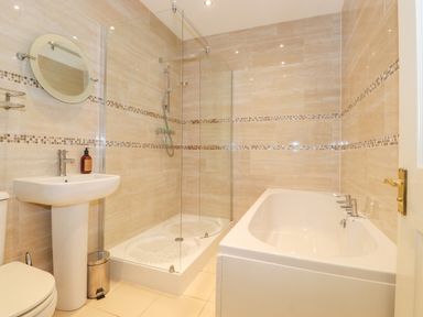 A bathroom with a shower, bathtub, sink, and toilet at Southview Amble in Amble
