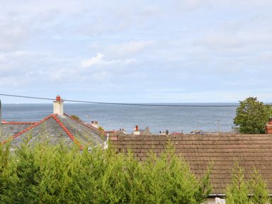 Rooftops and greenery with a view of the sea in the background at Willoway in Benllech