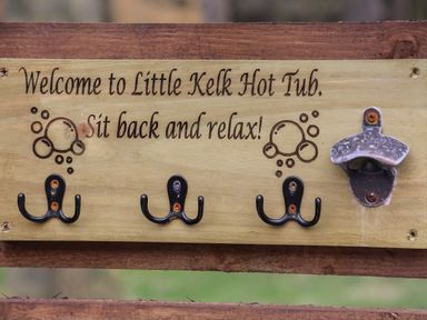 A wooden sign with hooks and a bottle opener at Little Kelk Hot Tub in Little Kelk near Bridlington