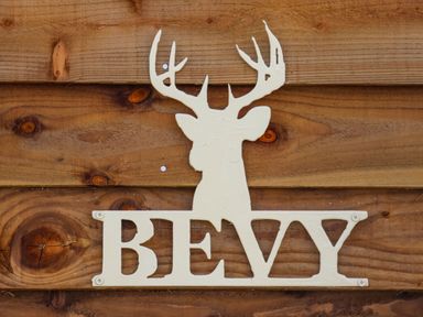 A wooden wall with a white metal deer head silhouette and the word BEVY mounted on it at Bevy Little Kelk near Bridlington