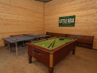 A game room with a pool table a ping pong table wooden benches and a wall sign at Husk in Little Kelk near Bridlington