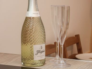 A bottle of Freixenet prosecco and two empty champagne flutes on a wooden table at Parliament in Little Kelk near Bridlington