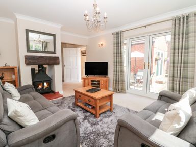 A living room with two sofas a coffee table a fireplace and a television at Church View in Withernwick near Aldbrough