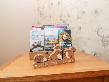 A wooden table with brochures and a wooden decoration saying enjoy every moment at Church View in Withernwick near Aldbrough