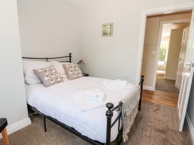 A bedroom with a bed white linens pillows and folded towels at Church View Withernwick near Aldbrough