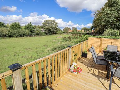 An outdoor space with a table and chairs overlooking a field at Church View in Withernwick near Aldbrough