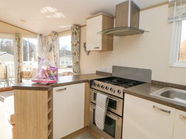 A kitchen with a gas stove oven sink and a countertop with a gift basket at 46 Willowburn in Felton