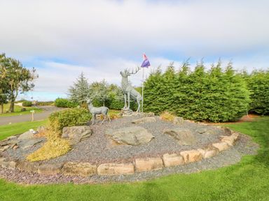 A garden area with two deer statues on a rocky mound bordered by stones at 46 Willowburn in Felton