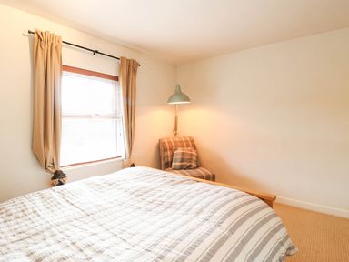 A bedroom with a bed and a chair at 5 Prospect Place in Woodbridge