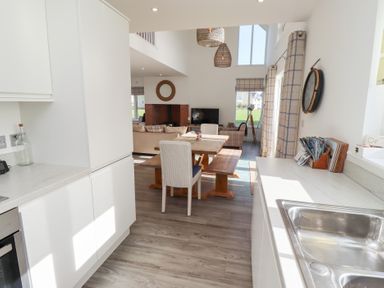A kitchen with a dining table and sofa at The Beach House in Beadnell