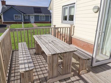 A wooden table and benches on an outdoor patio at The Beach House (Beadnell) Beadnell