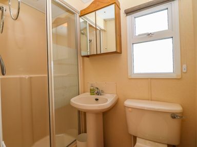 A bathroom with a shower enclosure sink toilet and a window at Cwrt y Ceffyl Boduan near Morfa Nefyn