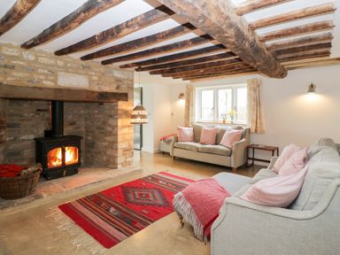 A living room with two sofas and a wood burning stove at High Cogges Farm Holiday Cottages Witney