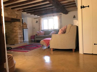 A living room with sofas pillows and a rug on the floor at High Cogges Farm Holiday Cottages Witney