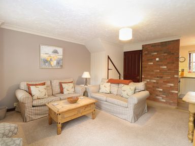 A living room with two striped sofas and a wooden coffee table at 10 Ruston Reaches East Ruston near Stalham