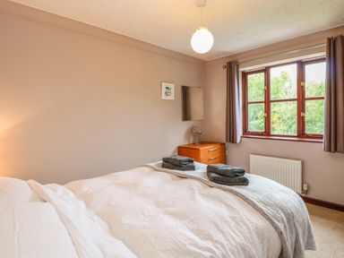 A bedroom with a bed covered in white bedding and towels on top at 10 Ruston Reaches East Ruston near Stalham