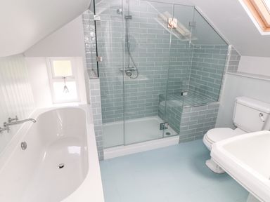 A bathroom with a bathtub shower with glass doors toilet and sink at 10 Westgate Hill Pembroke