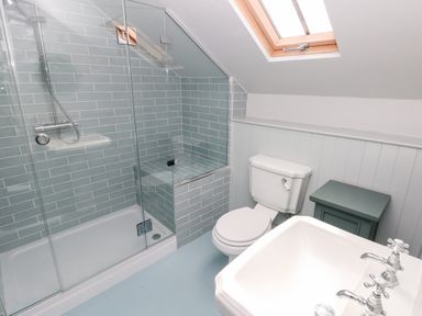 A bathroom with a glass shower enclosure toilet sink and a small cabinet at 10 Westgate Hill in Pembroke