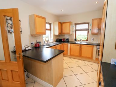 A kitchen with cupboards and a sink at Geesala in Gweesalia