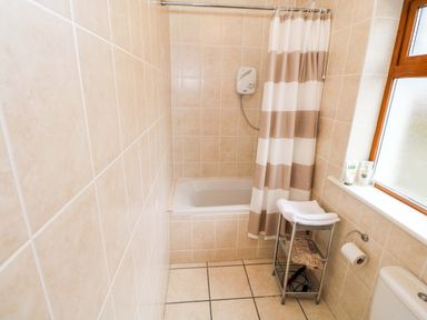 A bathroom with a bathtub, shower, and toilet at Geesala, Gweesalia