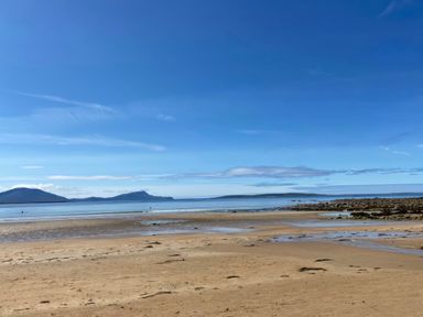 A beach with sand and sea under a clear sky at Geesala in Gweesalia