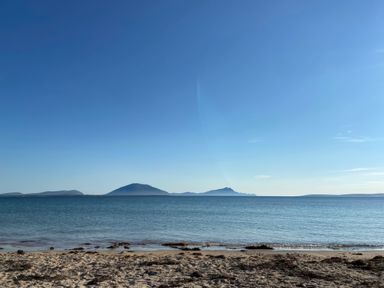 A beach view with mountains in the distance at Geesala in Gweesalia