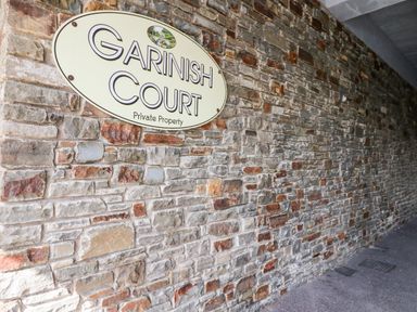A stone brick wall with a sign reading Garinish Court private property at 2 Garnish Court in Glengarriff County Cork