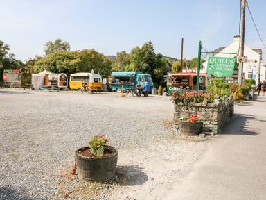 An outdoor food truck area with picnic tables and a sign for Quills customer car park at 2 Garnish Court in Glengarriff County Cork