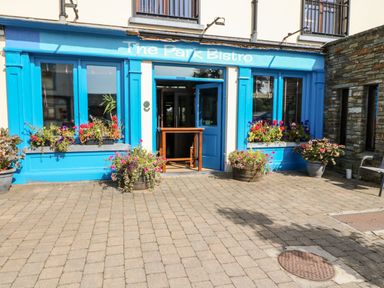 The entrance of The Park Bistro with blue framed windows and flower pots outside at 2 Garnish Court Glengarriff County Cork