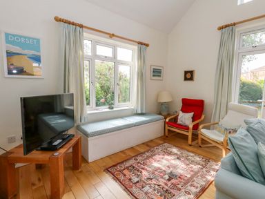A living room with a television and seating area at 1 Fernhill Avenue Weymouth