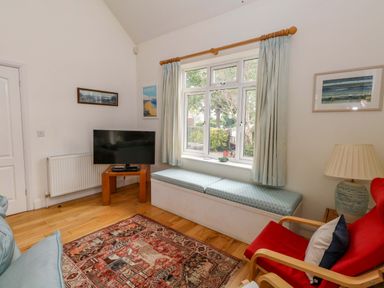A living room with a television and window seat at 1 Fernhill Avenue Weymouth