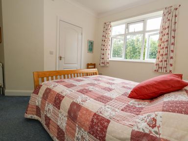 A bedroom with a bed and window at 1 Fernhill Avenue Weymouth