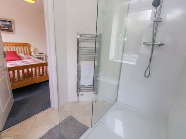 A bathroom with a shower and towel rail at 1 Fernhill Avenue Weymouth